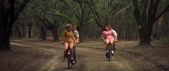 Movie still from “The Notebook” (2004), directed by Nick Cassavetes – A group of people riding bikes down a dirt road; Wide shot, High angle