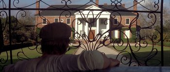 Movie still from “The Notebook” (2004), directed by Nick Cassavetes – A man looking out a window at a building; Wide shot, Over the shoulder angle