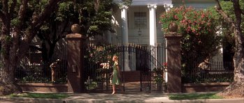 Movie still from “The Notebook” (2004), directed by Nick Cassavetes – A woman walking in front of an iron gate; Wide shot, Low angle