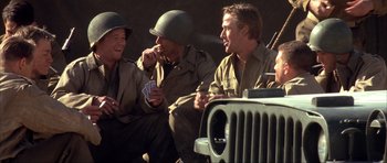 Movie still from “The Notebook” (2004), directed by Nick Cassavetes – A group of men sitting next to each other on the ground; Medium shot, Over the shoulder angle