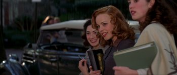 Movie still from “The Notebook” (2004), directed by Nick Cassavetes – Two young women smile while holding books and papers; Medium shot, Over the shoulder angle