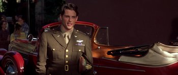 Movie still from “The Notebook” (2004), directed by Nick Cassavetes – A man in a military uniform standing in front of an antique car; Medium shot, Low angle