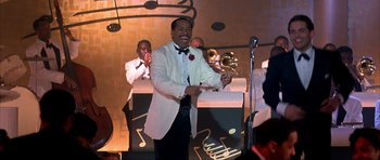 Movie still from “The Notebook” (2004), directed by Nick Cassavetes – A man in a white tuxedo holding a trophy; Medium shot, Over the shoulder angle