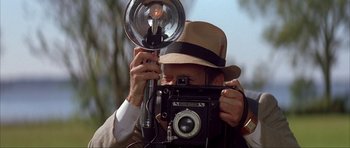 Movie still from “The Notebook” (2004), directed by Nick Cassavetes – An older man in a hat holding an old fashioned camera; Close Up shot, Low angle
