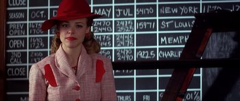 Movie still from “The Notebook” (2004), directed by Nick Cassavetes – A woman wearing a red hat standing in front of a wall of numbers; Medium shot, Over the shoulder angle