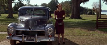 Movie still from “The Notebook” (2004), directed by Nick Cassavetes – A woman standing next to an old car; Wide shot, Low angle