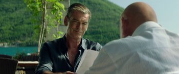 Movie still from “The November Man” (2014), directed by Roger Donaldson – A man sitting in front of another man holding a piece of paper; Close Up shot, Over the shoulder angle