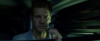 Movie still from “The November Man” (2014), directed by Roger Donaldson – A person in a car looking at the camera; Close Up shot, Over the shoulder angle