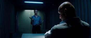 Movie still from “The November Man” (2014), directed by Roger Donaldson – A woman standing in front of a mirror in a room; Medium shot, Over the shoulder angle