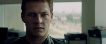 Movie still from “The November Man” (2014), directed by Roger Donaldson – A man's face in front of a window; Close Up shot, Over the shoulder angle