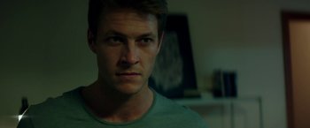 Movie still from “The November Man” (2014), directed by Roger Donaldson – A person wearing a green shirt; Close Up shot, Over the shoulder angle
