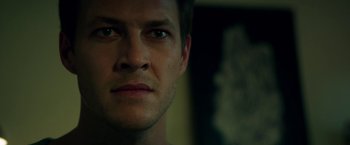 Movie still from “The November Man” (2014), directed by Roger Donaldson – A man's face in front of a painting; Close Up shot, Over the shoulder angle