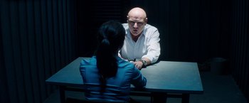 Movie still from “The November Man” (2014), directed by Roger Donaldson – A man and a woman sitting in front of a table; Medium shot, Over the shoulder angle