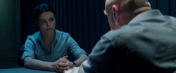 Movie still from “The November Man” (2014), directed by Roger Donaldson – Two people sitting at a table talking to each other; Medium shot, Over the shoulder angle