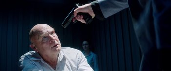 Movie still from “The November Man” (2014), directed by Roger Donaldson – A man holding a handgun up to another man's face; Close Up shot, Over the shoulder angle