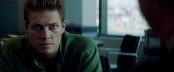 Movie still from “The November Man” (2014), directed by Roger Donaldson – A person wearing a green shirt; Close Up shot, Over the shoulder angle