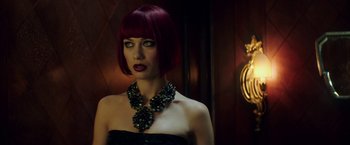 Movie still from “The November Man” (2014), directed by Roger Donaldson – A woman with red hair wearing a black dress; Close Up shot, Over the shoulder angle