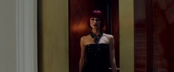 Movie still from “The November Man” (2014), directed by Roger Donaldson – A woman with red hair and a black dress in front of a door; Medium shot, Low angle