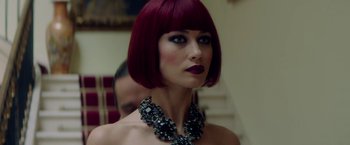 Movie still from “The November Man” (2014), directed by Roger Donaldson – A woman with red hair wearing a necklace; Close Up shot, Over the shoulder angle
