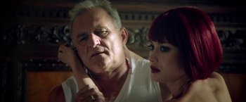 Movie still from “The November Man” (2014), directed by Roger Donaldson – An older man and a young woman looking at each other; Close Up shot, Low angle