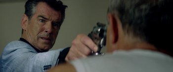 Movie still from “The November Man” (2014), directed by Roger Donaldson – A man holding a gun in his hand while another man looks at him; Close Up shot, Over the shoulder angle