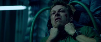 Movie still from “The November Man” (2014), directed by Roger Donaldson – A young man with a bleeding face is laying on a bed; Close Up shot, Low angle