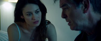 Movie still from “The November Man” (2014), directed by Roger Donaldson – A man and a woman sitting next to each other in a room; Close Up shot, Over the shoulder angle