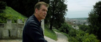 Movie still from “The November Man” (2014), directed by Roger Donaldson – A person sitting on a ledge; Medium shot, Over the shoulder angle