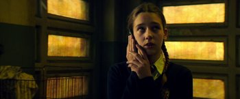 Movie still from “The November Man” (2014), directed by Roger Donaldson – A young girl holding a cell phone up to her ear; Close Up shot, Low angle