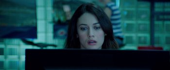 Movie still from “The November Man” (2014), directed by Roger Donaldson – A beautiful woman sitting in front of a computer monitor; Close Up shot, Over the shoulder angle