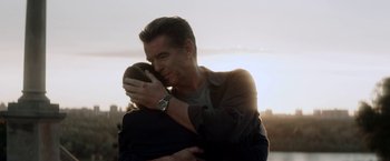 Movie still from “The November Man” (2014), directed by Roger Donaldson – A man hugging another man in front of a sunset; Close Up shot, Over the shoulder angle