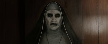 Movie still from “The Nun” (2018), directed by Corin Hardy – A painting of a woman with a nun costume; Close Up shot, High angle