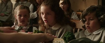 Movie still from “The Nun” (2018), directed by Corin Hardy – A group of young children sitting at a table; Close Up shot, Over the shoulder angle