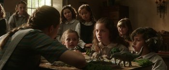 Movie still from “The Nun” (2018), directed by Corin Hardy – A group of children sitting around a table; Medium shot, Over the shoulder angle