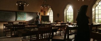 Movie still from “The Nun” (2018), directed by Corin Hardy – A woman standing in front of an empty classroom; Wide shot, Low angle