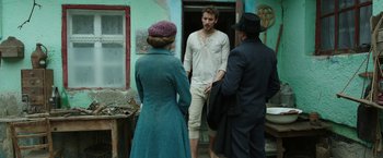 Movie still from “The Nun” (2018), directed by Corin Hardy – A group of people standing in front of a building; Medium shot, Over the shoulder angle