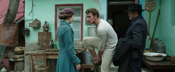 Movie still from “The Nun” (2018), directed by Corin Hardy – A man kneeling down next to a woman in front of a building; Medium shot, Low angle
