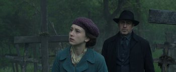 Movie still from “The Nun” (2018), directed by Corin Hardy – A woman in a hat and a man in a hat; Medium shot, Low angle