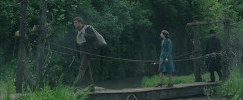 Movie still from “The Nun” (2018), directed by Corin Hardy – A man and a woman walking across a bridge; Wide shot, Over the shoulder angle