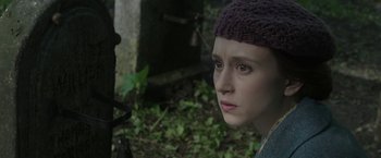 Movie still from “The Nun” (2018), directed by Corin Hardy – A young woman wearing a purple knitted hat; Close Up shot, Over the shoulder angle