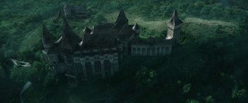 Movie still from “The Nun” (2018), directed by Corin Hardy – An aerial view of an old building in the middle of a forest; Extreme Wide shot, High angle