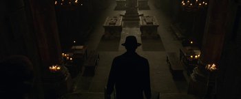 Movie still from “The Nun” (2018), directed by Corin Hardy – A man wearing a hat standing in the dark; Wide shot, Low angle