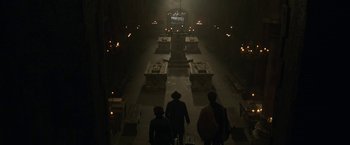 Movie still from “The Nun” (2018), directed by Corin Hardy – A group of people walking down a dark hallway; Wide shot, High angle