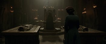 Movie still from “The Nun” (2018), directed by Corin Hardy – A woman standing in front of a large stone altar; Wide shot, Low angle