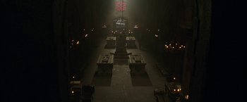 Movie still from “The Nun” (2018), directed by Corin Hardy – An empty room with candles lit in the middle of the floor; Extreme Wide shot, High angle
