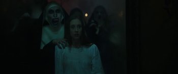 Movie still from “The Nun” (2018), directed by Corin Hardy – A group of people standing next to each other in the dark; Medium shot, Over the shoulder angle