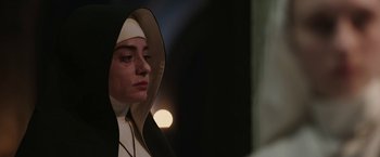Movie still from “The Nun” (2018), directed by Corin Hardy – A woman in a nun's outfit looking to her left; Close Up shot, Low angle
