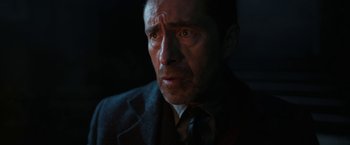 Movie still from “The Nun” (2018), directed by Corin Hardy – A person wearing a suit and tie; Close Up shot, Over the shoulder angle