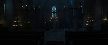 Movie still from “The Nun” (2018), directed by Corin Hardy – A person standing in front of a window in a church; Extreme Wide shot, Low angle