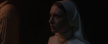 Movie still from “The Nun” (2018), directed by Corin Hardy – A woman wearing a nun's head covering looking to her left; Close Up shot, Low angle